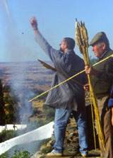 La siempre arriesgada tarea de lazar unos cuantos cohetes al aire, para llenar de sonido la fiesta, no impide que la brisa se llene del ruido de la p�lvora  el rastro del humo blanco que impulsa los proyectiles. 